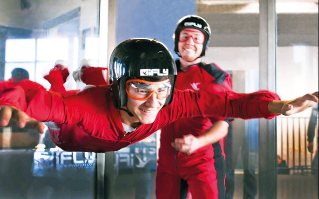 Smiling man flying at iFLY